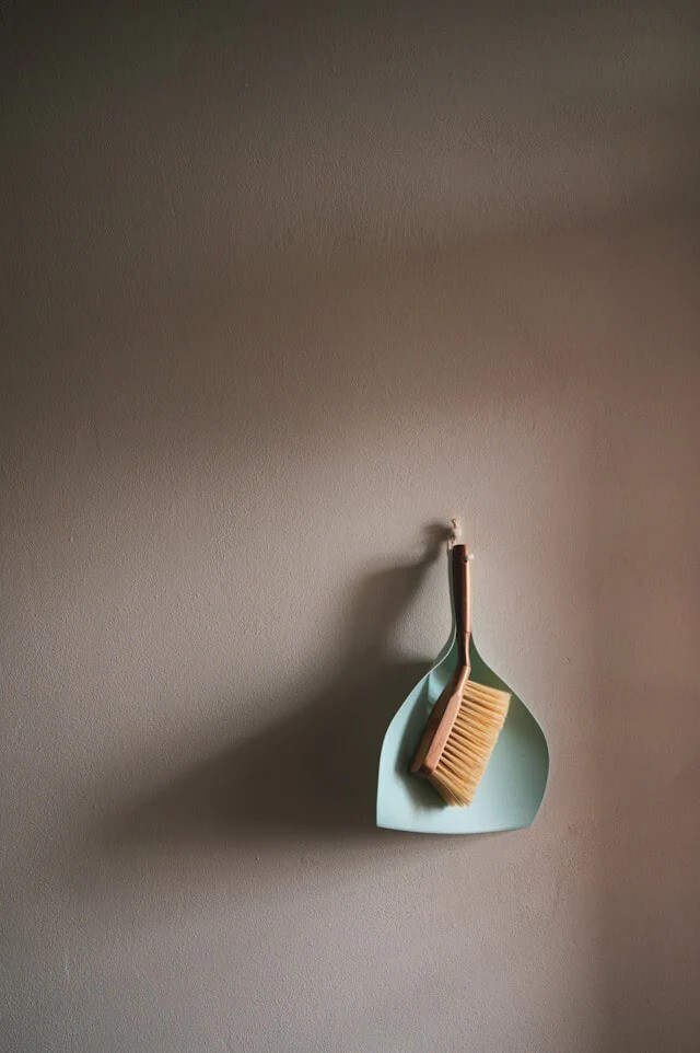 dust pan and brush on a wall